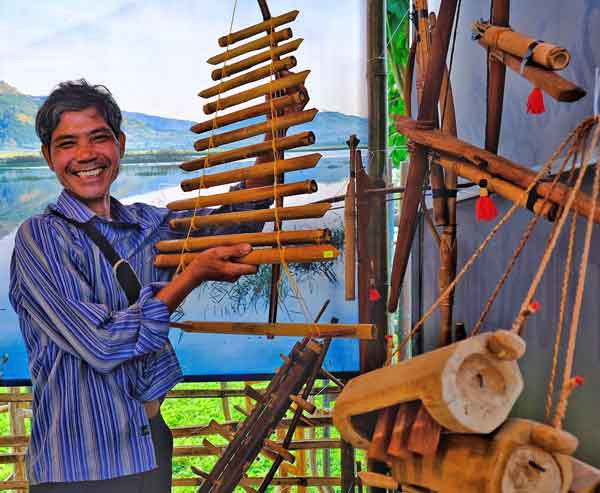 Nghệ nhân Rơ Châm Tih bên gian hàng giới thiệu sản phẩm thủ công truyền thống của mình. Ảnh: Minh Châu