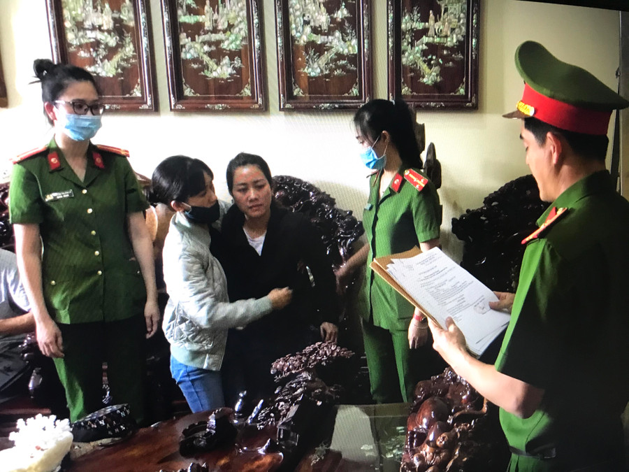 Điều tra viên đọc lệnh thi hành bắt tạm giam Chu Nữ Diệu Huyền (thứ 3 từ trái qua) tại nhà riêng của đối tượng. Ảnh: Lê Văn Ngọc Điều tra viên đọc lệnh thi hành bắt tạm giam với Huyền (thứ 3 từ trái qua) tại nhà riêng của đối tượng
