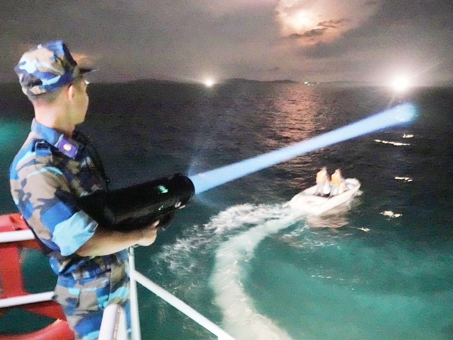 Chiến sĩ tàu CSB-3002 dùng đèn chuyên dụng phát hiện mục tiêu
