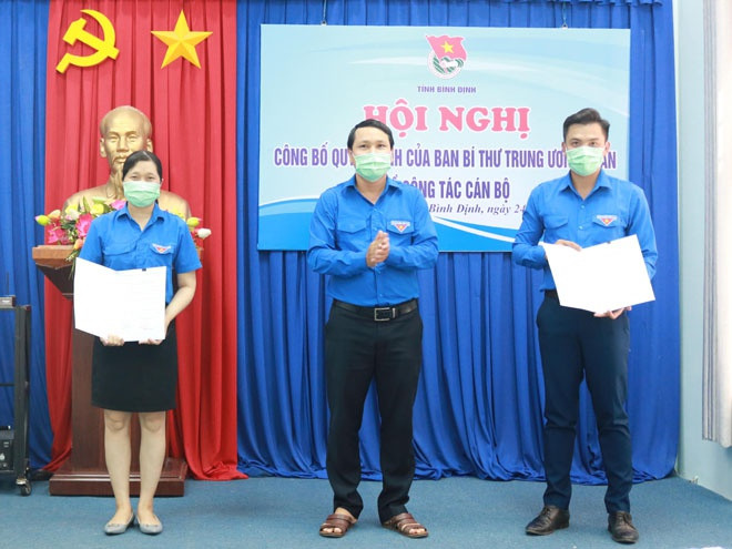 Anh Hà Duy Trung, Bí thư Tỉnh đoàn Bình Định (ở giữa), trao quyết định của Ban Bí thư Trung ương Đoàn cho chị Nguyệt và anh Hiệp. Ảnh: ÚT LỆ