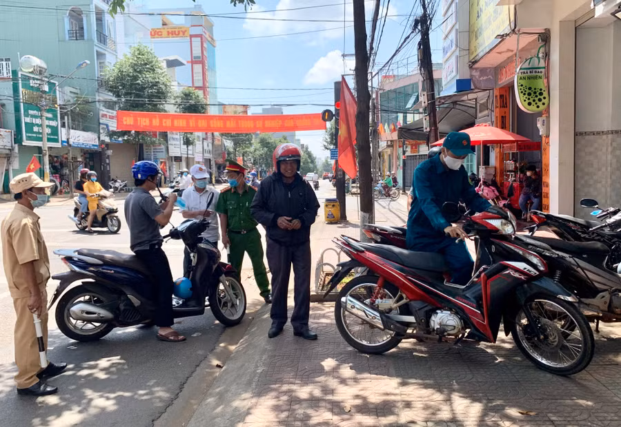 -Nhiều người dân còn chủ quan không đeo khẩu trang khi ra ngoài đường trong sáng 1-5 bị lực lượng chức năng lập biên bản. Ảnh: Như Nguyện 