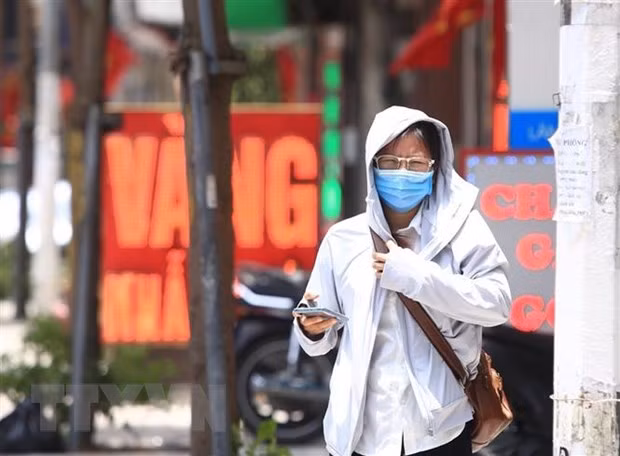 Người đi bộ khó chịu với thời tiết trong đợt nắng, nóng tại Hà Nội. (Ảnh: Hoàng Hiếu/TTXVN)