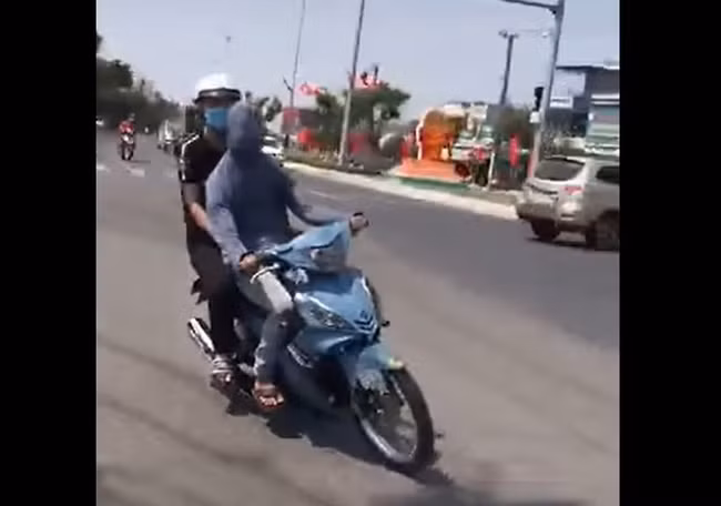 Hình ảnh nam thanh niên trùm kín mặt, che cả mắt, không đội mũ bảo hiểm, điều khiển xe máy theo chỉ dẫn của người phía sau được lan truyền trên mạng xã hội.