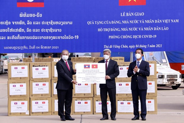 Thứ trưởng Bộ Y tế Nguyễn Trường Sơn đang trao tượng trưng 2 triệu khẩu trang y tế và 200 máy thở và các vật tư y tế là quà tặng của Đảng, Nhà nước và nhân dân Việt Nam dành cho Đảng, Nhà nước và nhân dân Lào trong công tác phòng chống COVID-19. (Ảnh: Phạm Kiên/TTXVN)