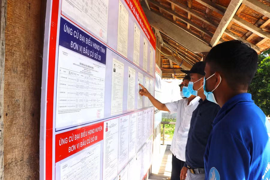 2 Các cử tri làng Đê Chơ Gang, xã Phú An, huyện Đak Pơ tìm hiểu tiểu sử của các ứng cử viên trước khi đi bỏ phiếu. Ảnh: Ngọc Minh