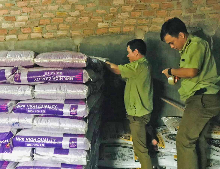 Lực lượng QLTT tiến hành lấy mẫu phân bón để kiểm định chất lượng. Ảnh: Vũ Thảo