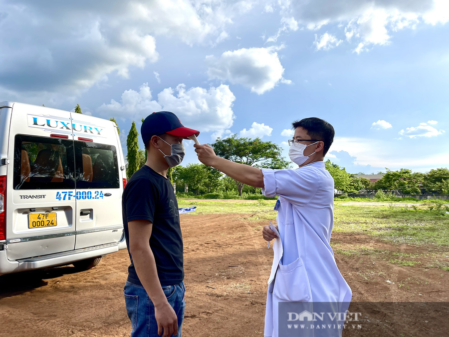 Nhân viên y tế thực hiện đo thân nhiệt.