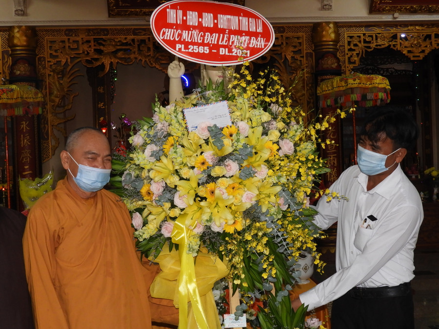 Phó Trưởng Ban Dân vận Tỉnh ủy Rơ Chăm La Ni (phải) tặng lẵng hoa chúc mừng Đại lễ Phật đản