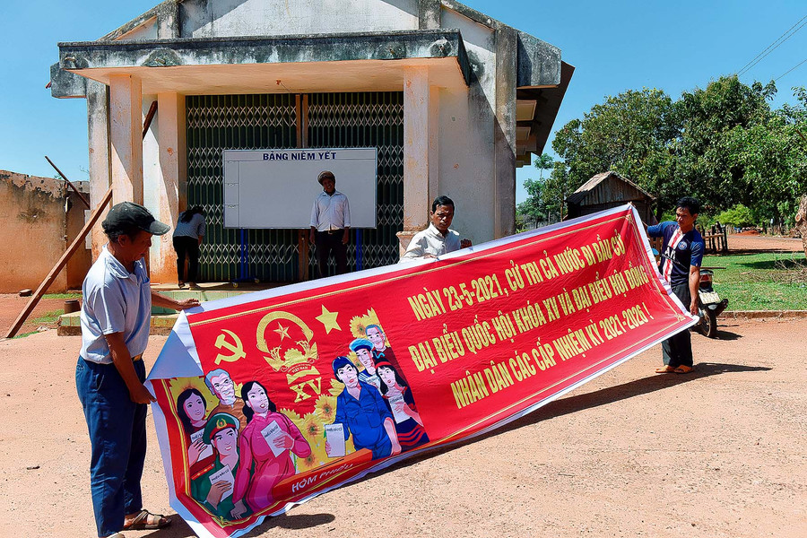 Người có uy tín ở xã Đăk Trôi, huyện Mang Yang tham gia treo các tấm băng rôn, pa nô tuyên truyền về bầu cử.