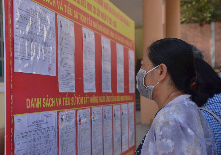 10-5 Cử tri phường Tây Sơn theo dõi thông tin của các ứng cử viên được niêm yết trước UBND phường Tây Sơn trước khi vào Hội nghị tiếp xúc cử tri-ảnh Phương Linh