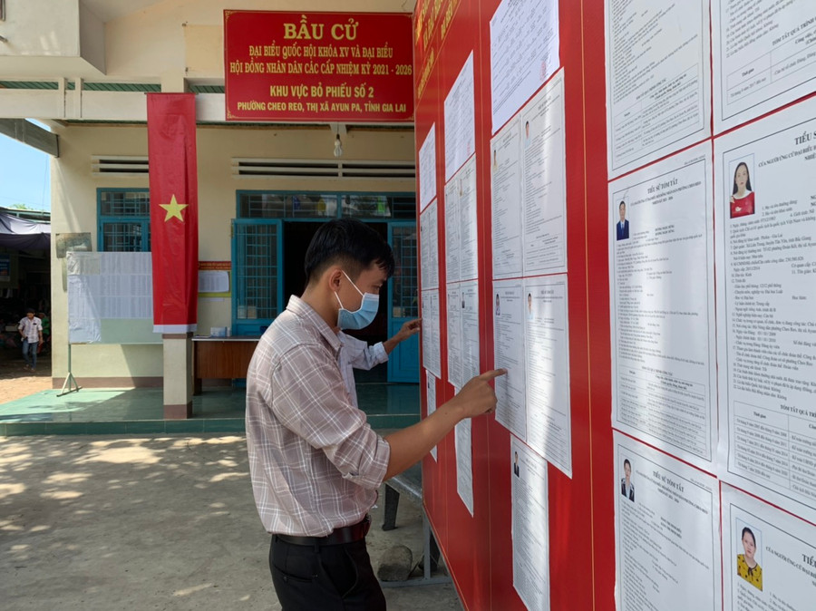  Người dân tranh thủ xem thông tin về các ứng cử viên tại đơn vị bầu cử số 2 (phường Cheo Reo, thị xã Ayun Pa)- Ảnh Vũ Chi