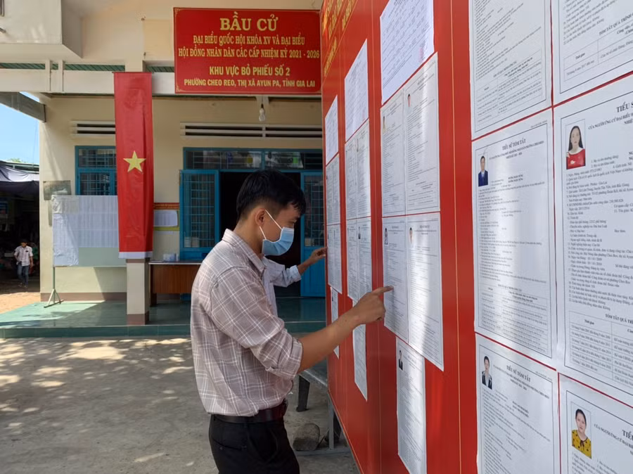  Người dân tranh thủ xem thông tin về các ứng cử viên tại đơn vị bầu cử số 2 (phường Cheo Reo, thị xã Ayun Pa)- Ảnh Vũ Chi