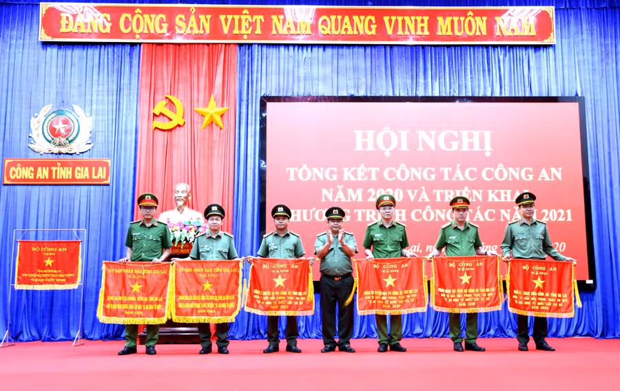 Thiếu tá Vũ Ngọc Trìu (thứ 2 từ trái sang, Phó Trưởng phòng Công tác Đảng và Công tác chính trị)nhận cờ đơn vị dẫn đầu phong trào thi đua “Vì an ninh Tổ quốc” của UBND tỉnh. Ảnh: Văn Ngọc