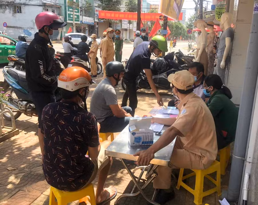Lực lượng chức năng phường Hội Thương (TP. Pleiku) lập biên bản xử phạt hành chính người dân không đeo khẩu trang nơi công cộng. Ảnh: Hồ Anh Tiến