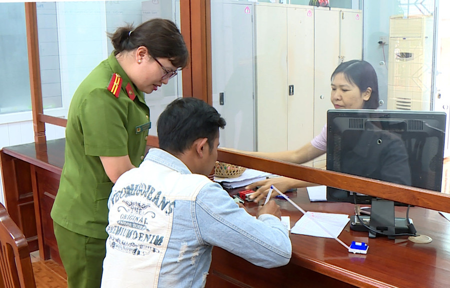 Hình 2: Thiếu tá Trần Thị Luận – Phó đội trưởng Đội Hỗ trợ tư pháp Công an huyện Đak Đoa hướng dẫn anh Trần Châu Hổ làm thủ tục vay vốn Ngân hàng. 