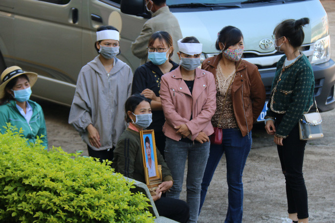 Gia đình nạn nhân mang di ảnh của anh Trần Nho Vương tới tòa