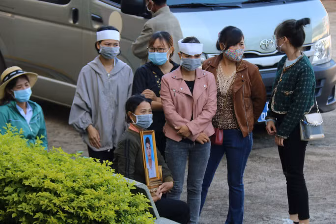 Gia đình nạn nhân mang di ảnh của anh Trần Nho Vương tới tòa