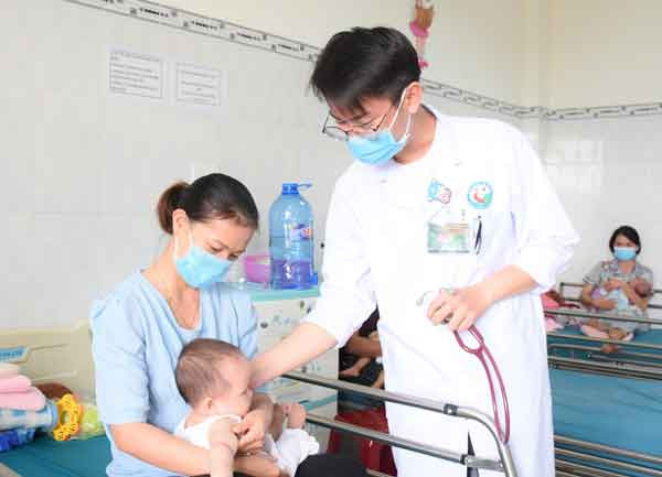 Bác sĩ Phạm Đỗ Hoài Phong ân cần thăm khám bệnh nhi. Ảnh: Phương Duyên