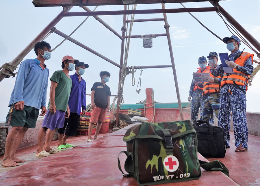 Cán bộ, chiến sĩ tàu CSB-3002 tuyên truyền các biện pháp phòng chống dịch Covid-19 với ngư dân làm việc trên biển