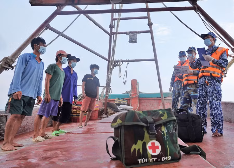 Cán bộ, chiến sĩ tàu CSB-3002 tuyên truyền các biện pháp phòng chống dịch Covid-19 với ngư dân làm việc trên biển