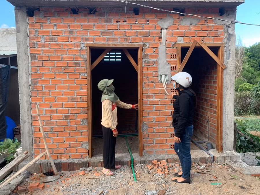 Gia đình chị Nguyễn Thị Lam (bìa trái, thôn 1, xã Pờ Tó) đang xây dựng nhà tắm, nhà tiêu hợp vệ sinh. Ảnh: Vũ Chi