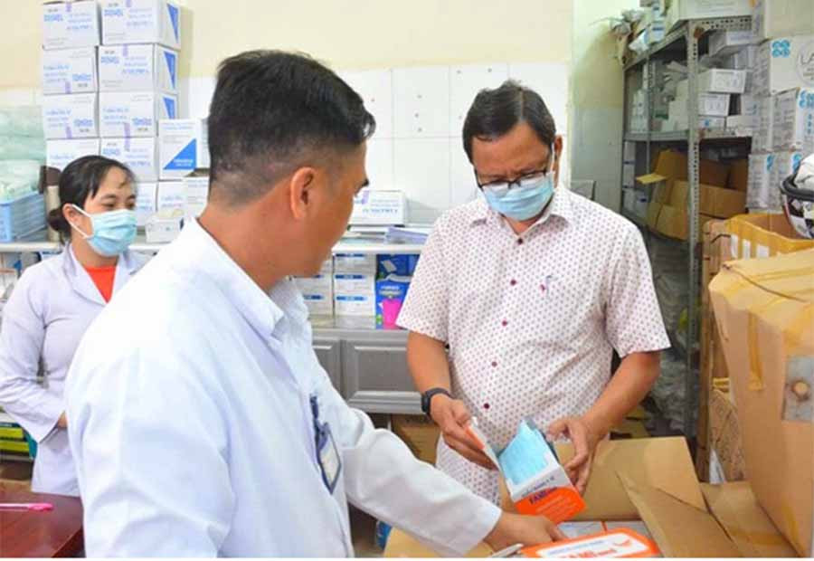 Bí thư Huyện ủy Vĩnh Thuận (đeo khẩu trang) đang kiểm tra vật tư y tế tại Trung tâm Y tế huyện này. Ảnh: B.H