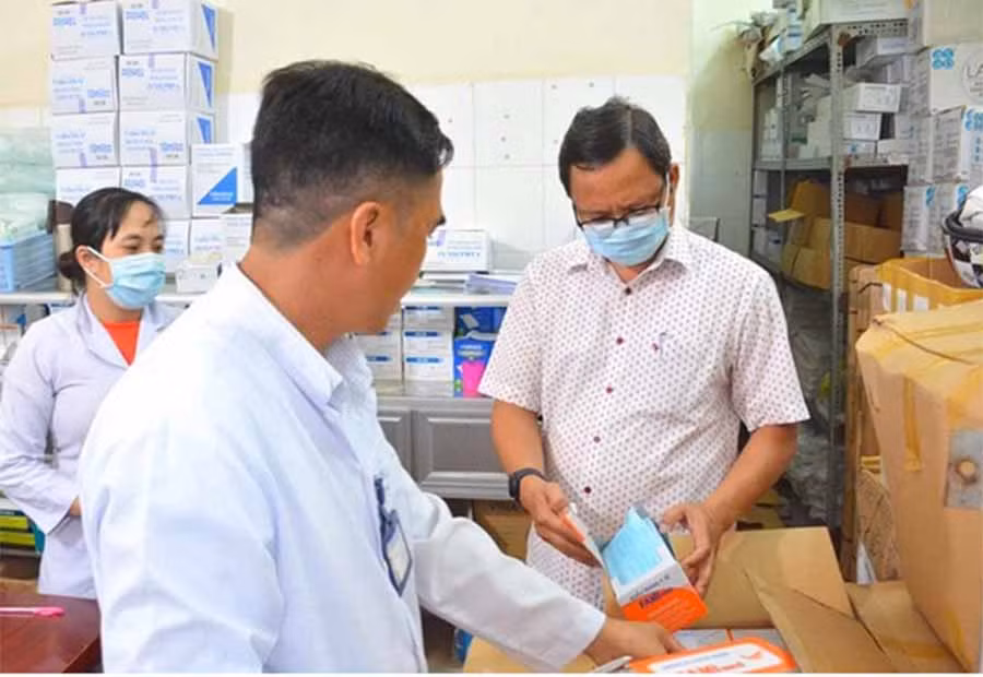 Bí thư Huyện ủy Vĩnh Thuận (đeo khẩu trang) đang kiểm tra vật tư y tế tại Trung tâm Y tế huyện này. Ảnh: B.H