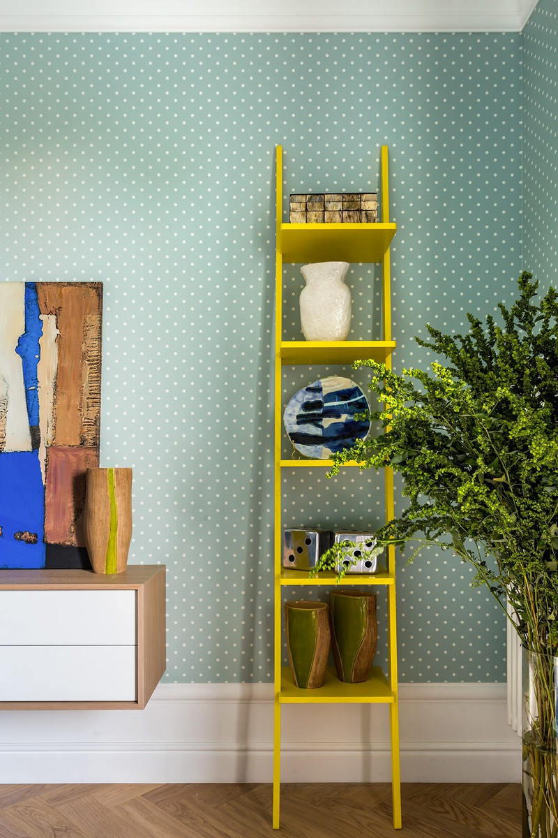 Kệ thang màu vàng tạo sự tương phản ở cuối phòng.