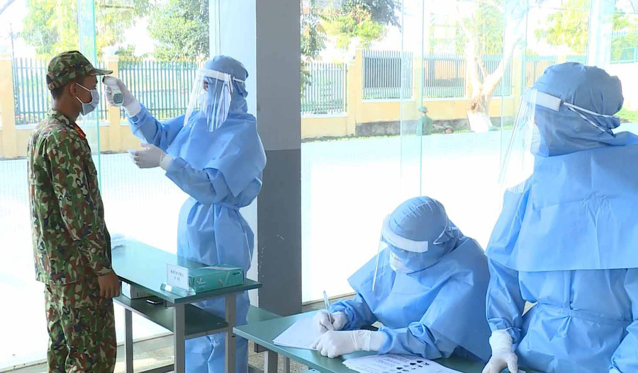 Cán bộ y tế kiểm tra thân nhiệt. Ảnh: Vĩnh Hoàng 