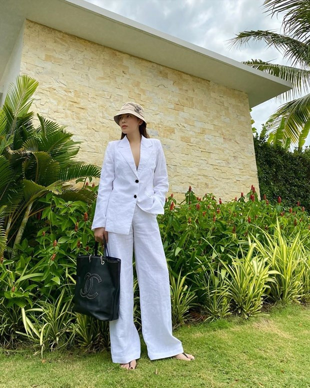 Trong khi loạt người đẹp lăng xê trang phục tuyền đen, Kỳ Duyên lại mê mẩn bộ cánh tuyền trắng. Hoa hậu kết hợp blazer với quần ống rộng, nhấn nhá bằng túi tote Chanel bản lớn.