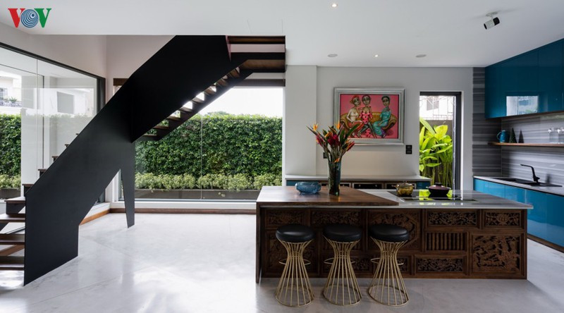 Ở phòng khách có thể ngắm nhìn bể bơi và sân vườn. Nội thất được phối giữa màu trắng và màu nâu trầm tạo vẻ sang trọng. Chiếc ghế màu vàng nổi bật trong không gian.