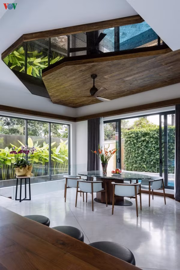 Phòng ăn thoáng rộng cũng hướng ra bể bơi. Trần nhà sử dụng gương tạo những hiệu ứng khác lạ đầy lôi cuốn.