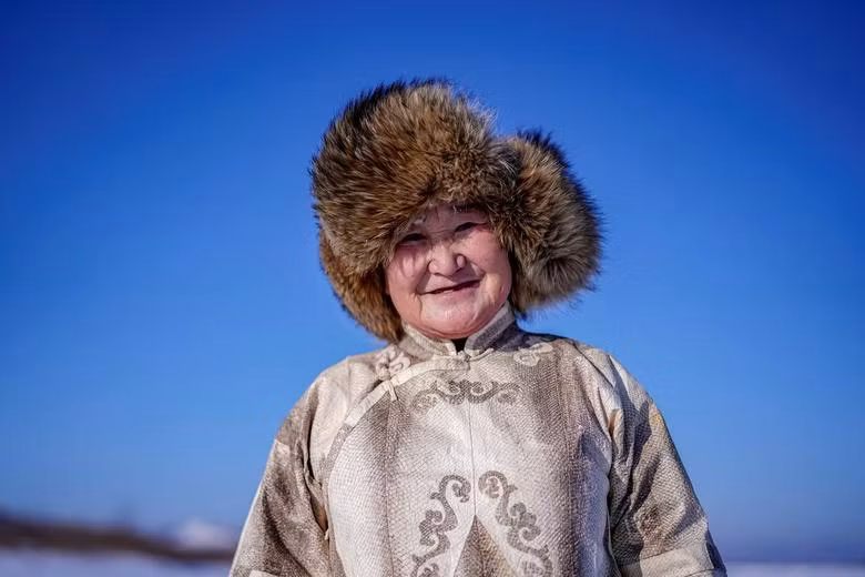 Bà You Wenfeng, 68 tuổi, một phụ nữ dân tộc Heanch, mặc bộ quần áo truyền thống làm từ da cá tại một con sông đóng băng ở Đồng Giang, tỉnh Hắc Long Giang, Trung Quốc ngày 1.1.2020. Ảnh: Reuters