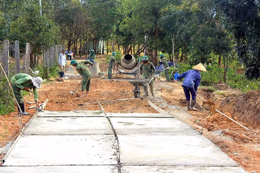 Giúp dân làm đường giao thông nông thôn. Ảnh: Ngọc Sang