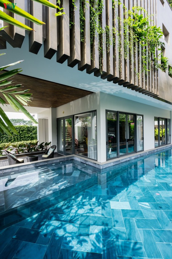 Tầng 1 là một không gian thoáng đãng với bể bơi ôm lấy chân ngôi nhà, sát phòng khách.