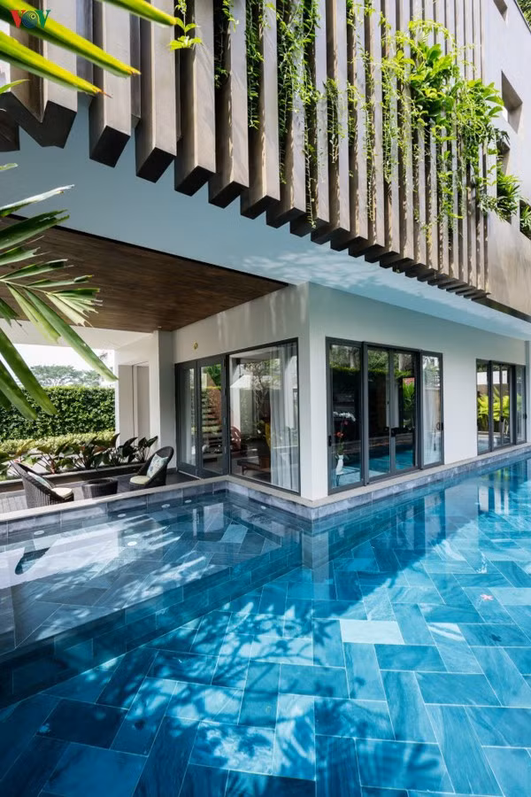 Tầng 1 là một không gian thoáng đãng với bể bơi ôm lấy chân ngôi nhà, sát phòng khách.