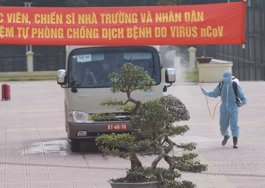 Phun tiêu độc khử trùng xe đưa đón người cách ly. Ảnh T.Vương