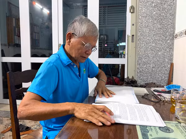 Ông Trần Chín ghi chép lại những tư liệu từ khi còn trong Nhà lao Pleiku để kể lại cho khách đến tham quan. Ảnh: P.L