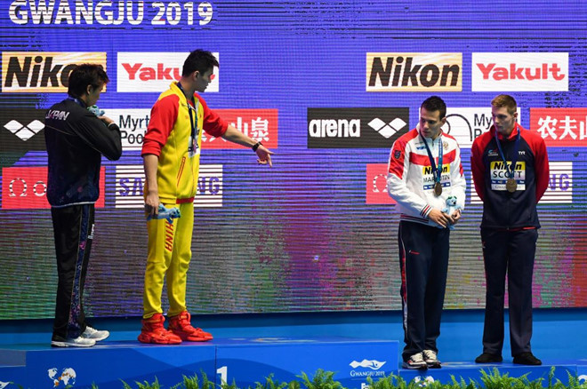 Sun Yang (áo vàng) bị nhiều VĐV từ chối bắt tay và đứng chung bục huy chương ở giải thế giới năm ngoái/ AFP