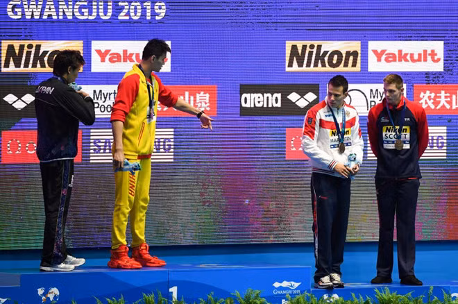 Sun Yang (áo vàng) bị nhiều VĐV từ chối bắt tay và đứng chung bục huy chương ở giải thế giới năm ngoái/ AFP