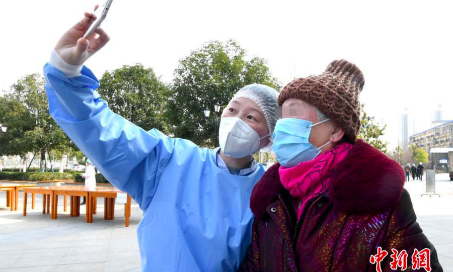 Nhân viên y tế chụp ảnh cùng một bệnh nhân lớn tuổi khi nhóm 11 bệnh nhân mắc COVID-19 nghiêm trọng xuất viện tại khu viện Trung Pháp Tân Thành của Bệnh viện Đồng Tế thuộc Đại học Khoa học kỹ thuật Hoa Trung - Ảnh: Chinanews