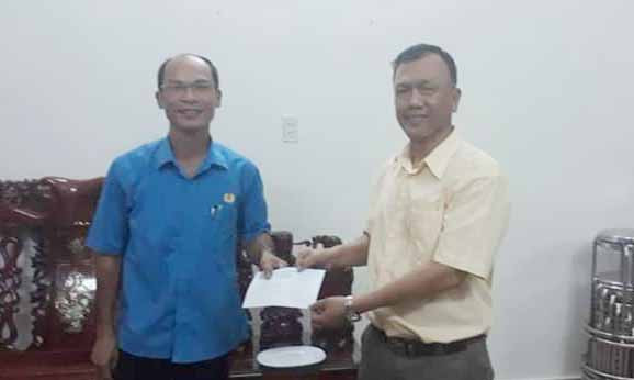 Đồng chí Nguyễn Hữu Thành-Chủ tịch LĐLĐ huyện tặng quà đoàn viên Phạm Văn Nhân. Ảnh: Vũ Thị Chi