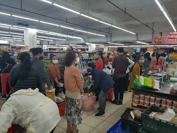  Người dân mua hàng tại siêu thị trong sáng 7/3. (Ảnh: Đức Duy/Vietnam+)