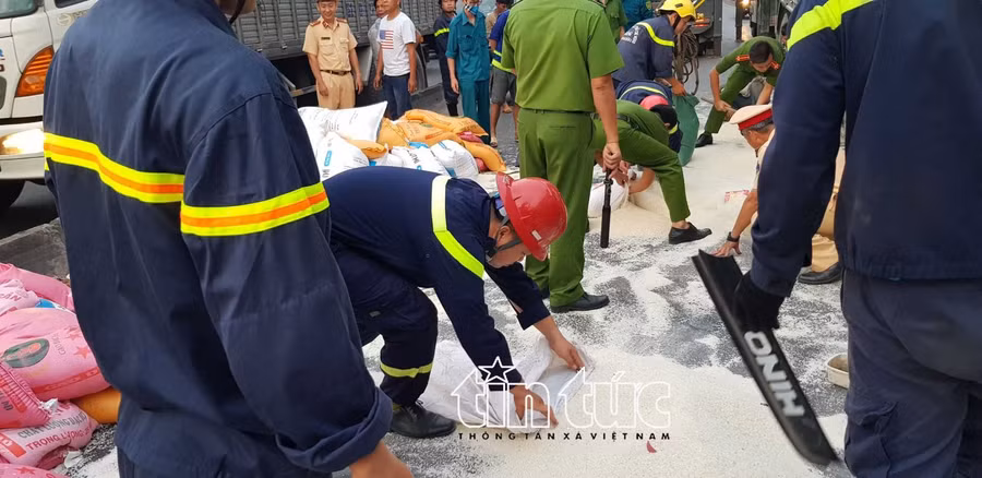 Lực lượng chức năng thu gom gạo bị đổ ra ngoài đường.