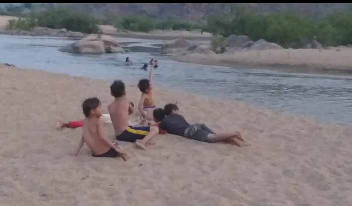 Bãi cát bồi giữa lòng sông, còn là địa điểm cho mấy đứa nhỏ chơi đùa. Chúng thoải mái lăn lộn trên cát, đứa nọ nằm trên lưng đứa kia ngắm ánh mặt trời đang từ từ khuất sau dãy núi .Ảnh: Vũ Thị Chi 