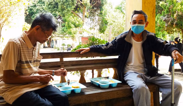 Các y-bác sĩ Bệnh viện 331 phát cơm cho bệnh nhân nghèo. Ảnh: N.N