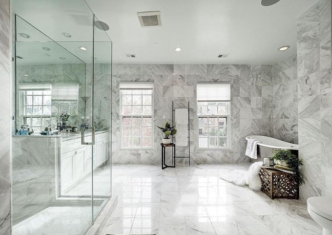 Phòng tắm là không gian khá lớn được lát đá xung quanh, cửa sổ đón ánh sáng tự nhiên với điểm nhấn là những chậu cây nhỏ.