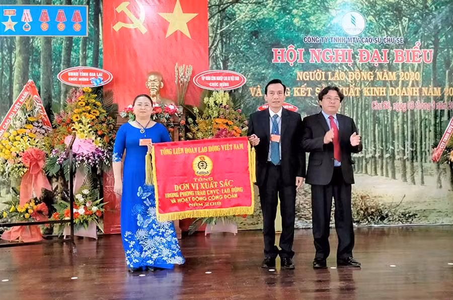 Ông Phan Mạnh Hùng-Chủ tịch Công đoàn Cao su Việt Nam (bìa phải) tặng Cờ thi đua xuất sắc của Tổng Liên đoàn Lao động Việt Nam cho Công đoàn Công ty Cao su Chư Sê. Ảnh: Đinh Yến