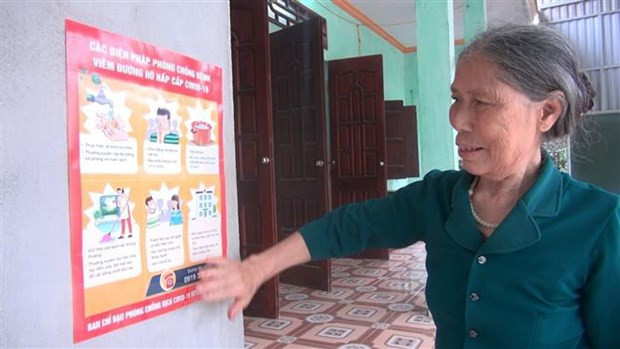 Bà Lê Thị Niệm dán tờ rơi hướng dẫn cách phòng chống dịch COVID-19 ngay trước cửa nhà. (Ảnh: Hoa Mai/TTXVN) Bà Lê Thị Niệm dán tờ rơi hướng dẫn cách phòng chống dịch COVID-19 ngay trước cửa nhà. (Ảnh: Hoa Mai/TTXVN)