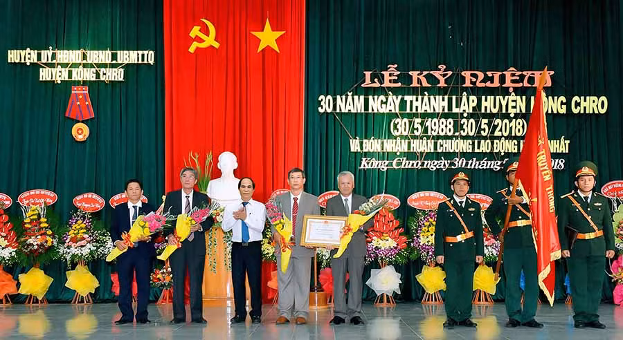 Thừa ủy nhiệm của Chủ tịch nước, Chủ tịch UBND tỉnh Võ Ngọc Thành (thứ 3 từ trái sang) trao Huân chương Lao động hạng nhất cho huyện Kông Chro nhân dịp kỷ niệm 30 năm Ngày thành lập huyện (30/5/1988-30/5/2018). Ảnh: Đ.T